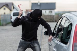 Thief breaking into a vehicle